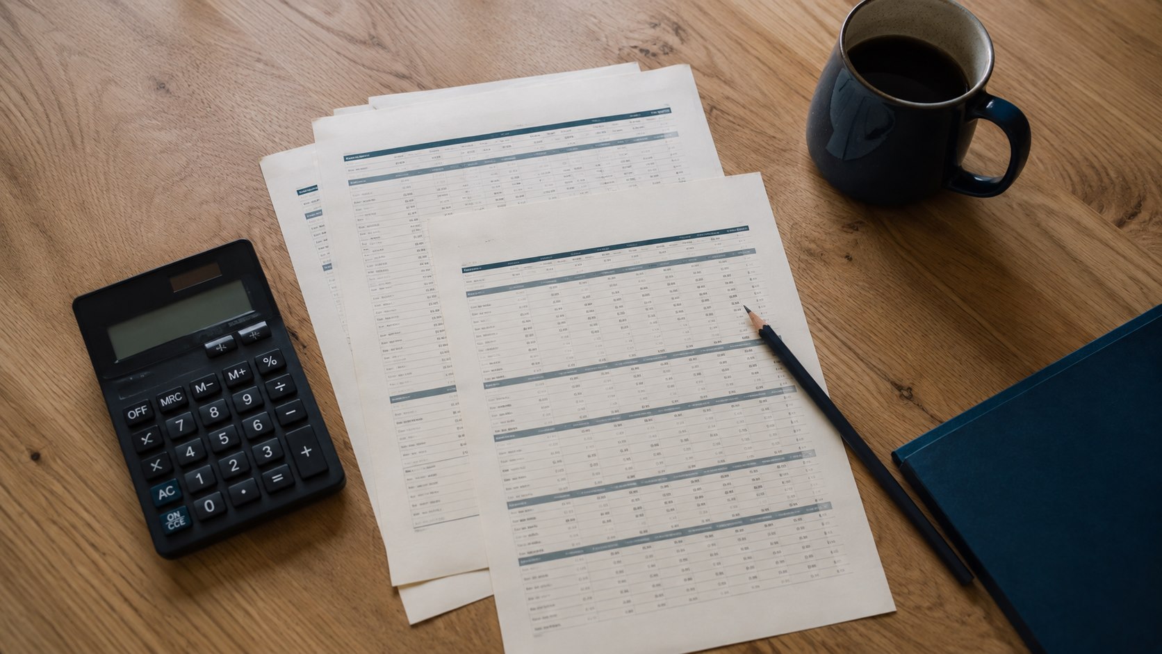 Calculator and comparison worksheets arranged on a desk.